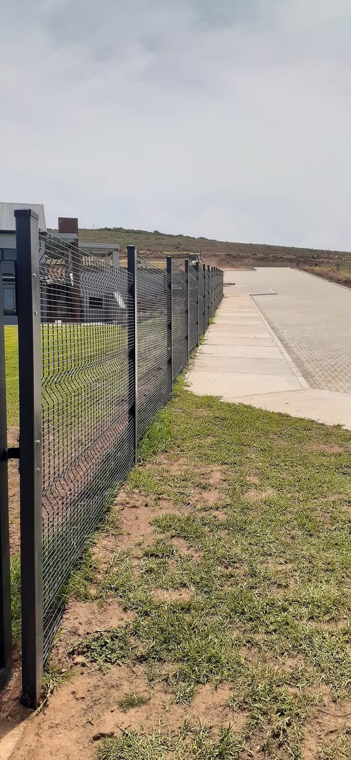 Black Clearview fence along a paved walkway at King's College, Outeniqua Bosch
