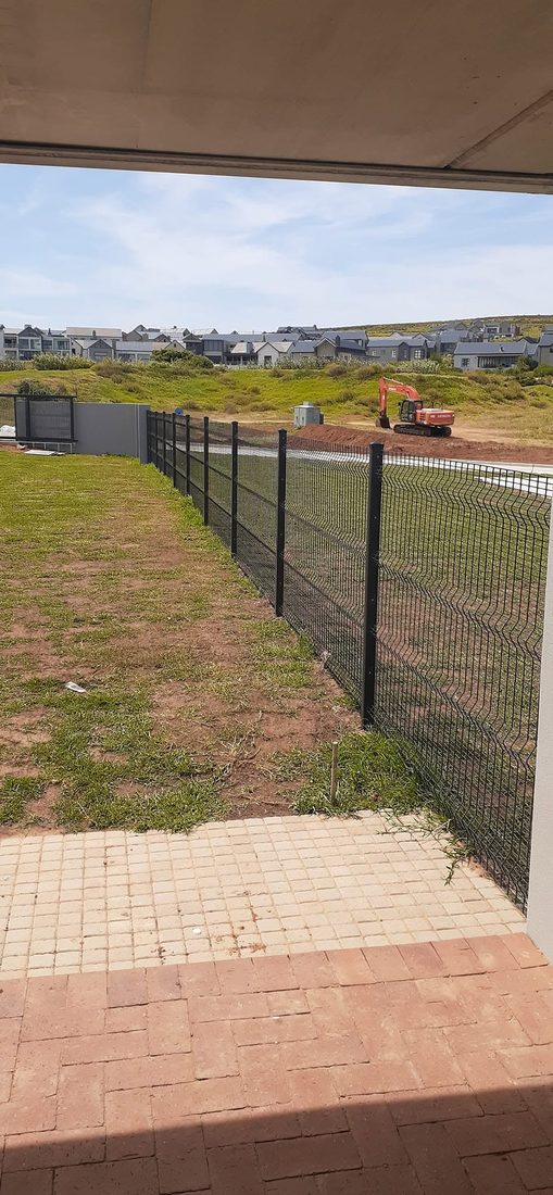 Clearview fence enclosing the school field, viewed from a covered walkway